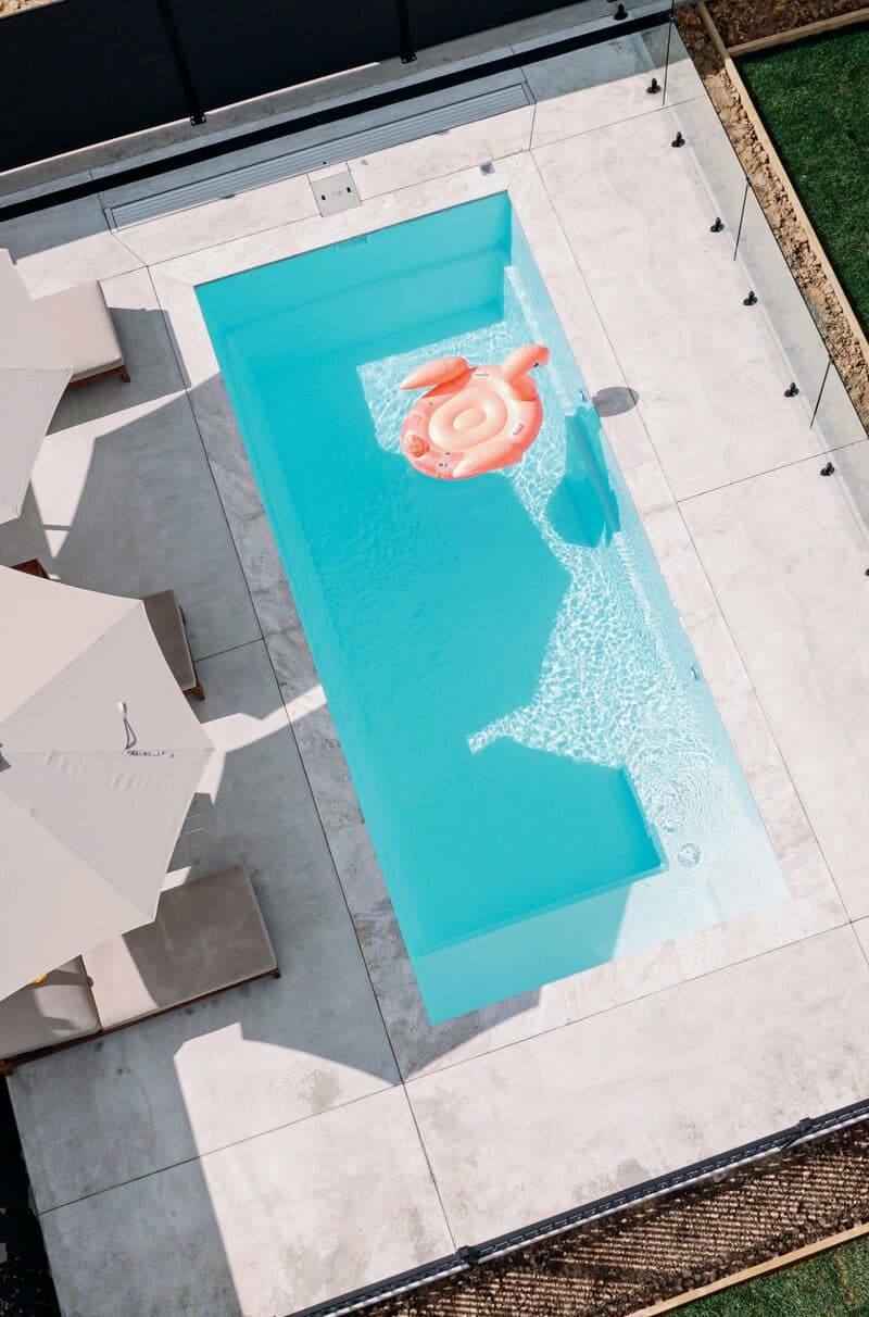 Drone view straight down onto a Kiwi Dream 6 pool, umbrellas beside it