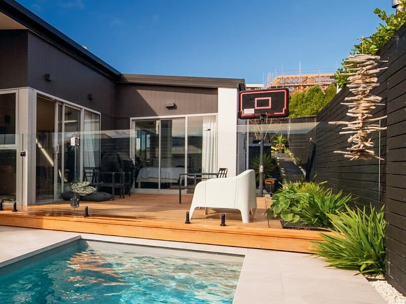 A Kiwi Urban 5 pool running up to a timber deck and glass fence
