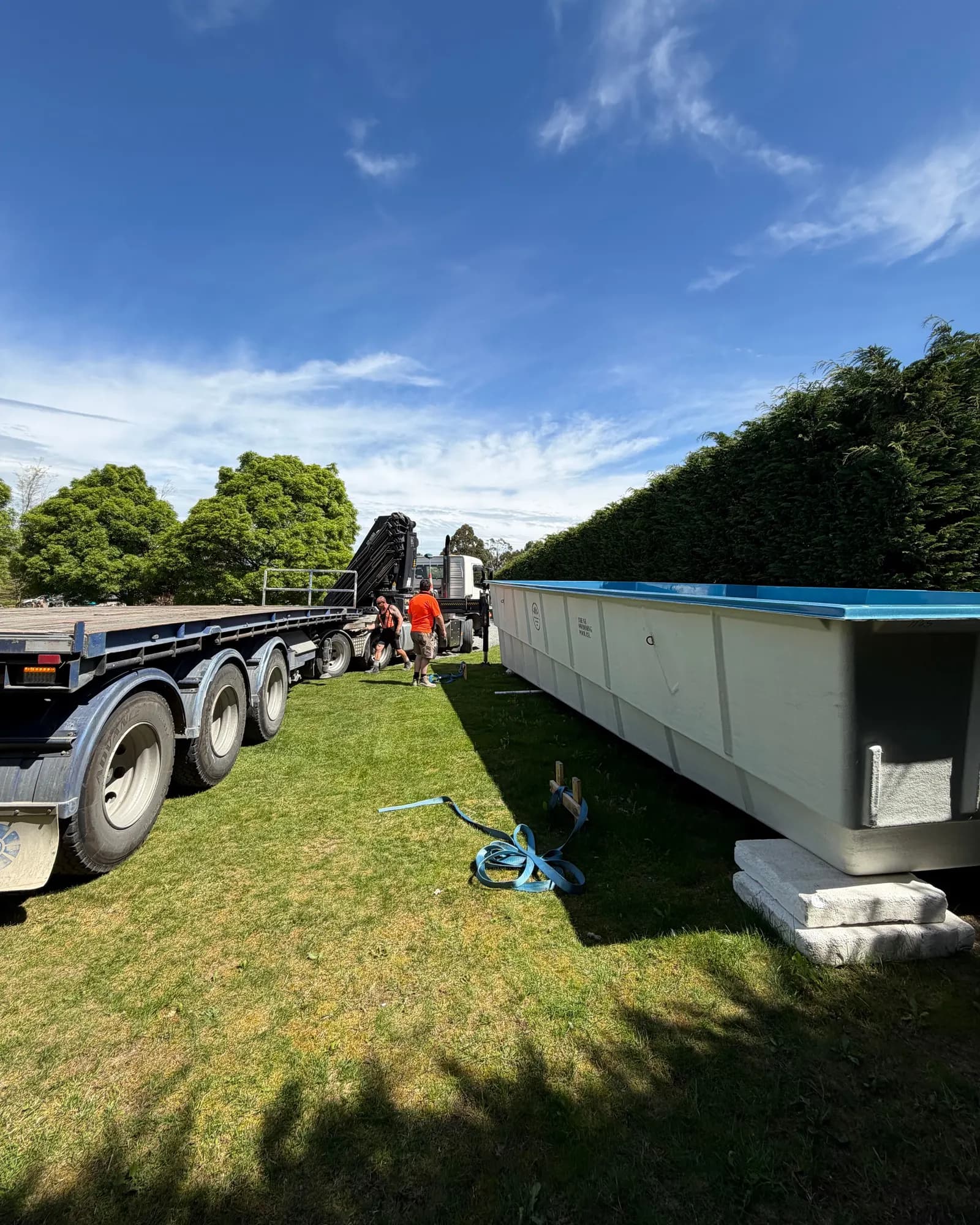 A fibreglass shell on blocks on the lawn beside the truck that delivered it