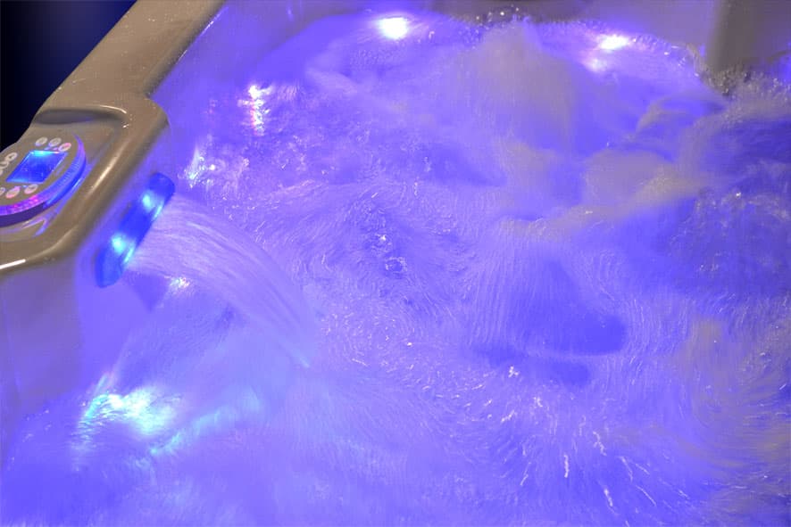 A spa's water bubbling under blue and purple lights