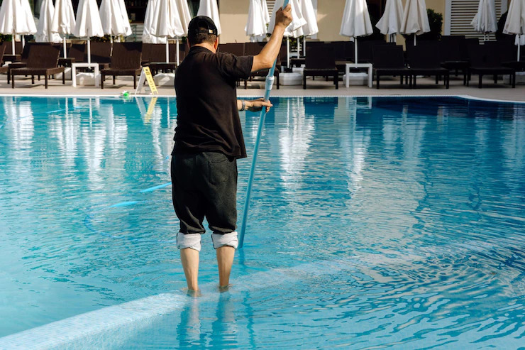 man-cleans-swimming-pool